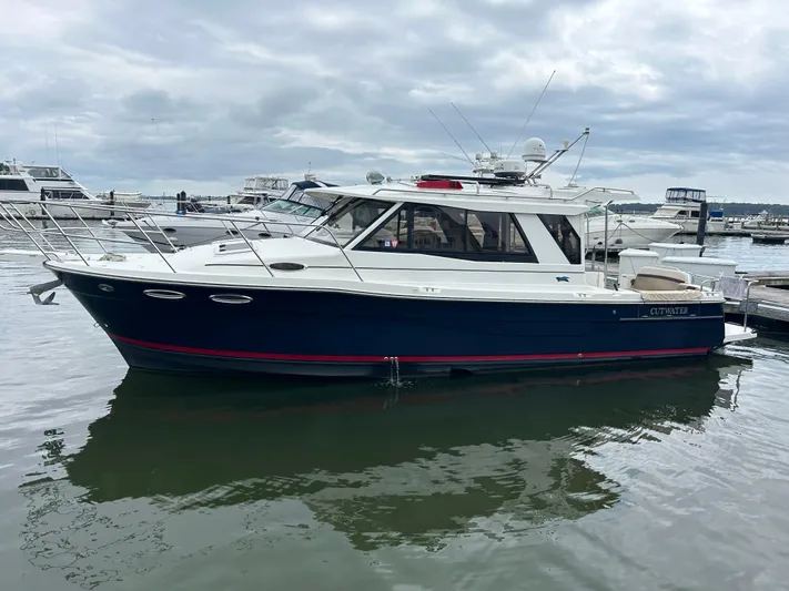 Yacht Photos Pics 2014 Cutwater C-30 Sedan boat docked in a marina under cloudy skies.
