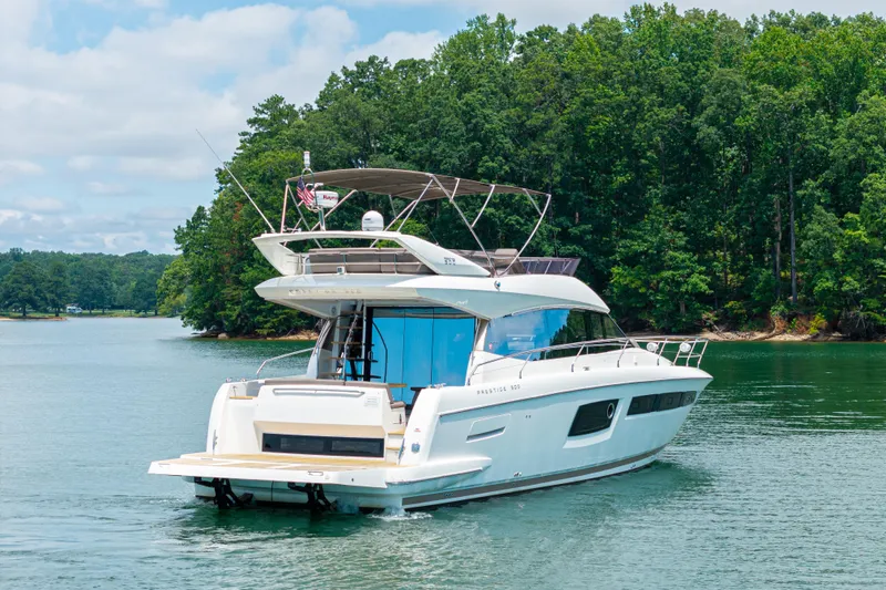  Yacht Photos Pics 2017 Prestige 500 yacht cruising on a serene lake with lush green forest backdrop.