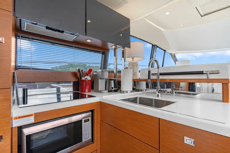  Yacht Photos Pics Modern kitchen interior on a 2017 Prestige 500 yacht, featuring sleek appliances and wooden cabinetry.