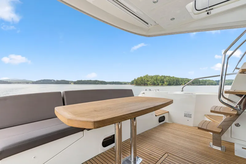  Yacht Photos Pics Prestige 500 yacht 2017 model, featuring elegant deck seating and wooden table with scenic water view.