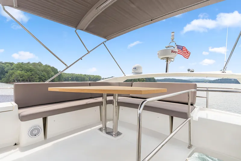  Yacht Photos Pics 2017 Prestige 500 yacht deck with seating, table, and American flag on a sunny day.