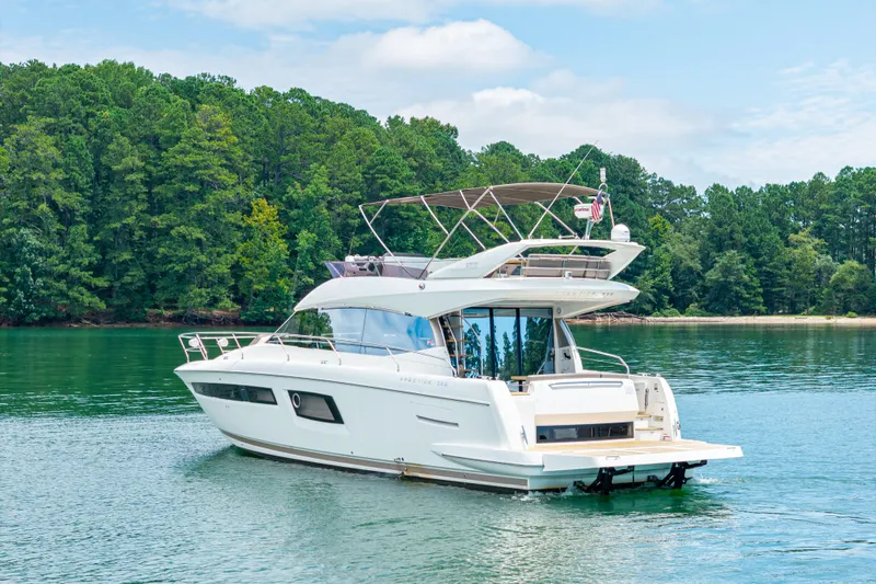  Yacht Photos Pics 2017 Prestige 500 yacht cruising on a serene lake with lush green forest backdrop.