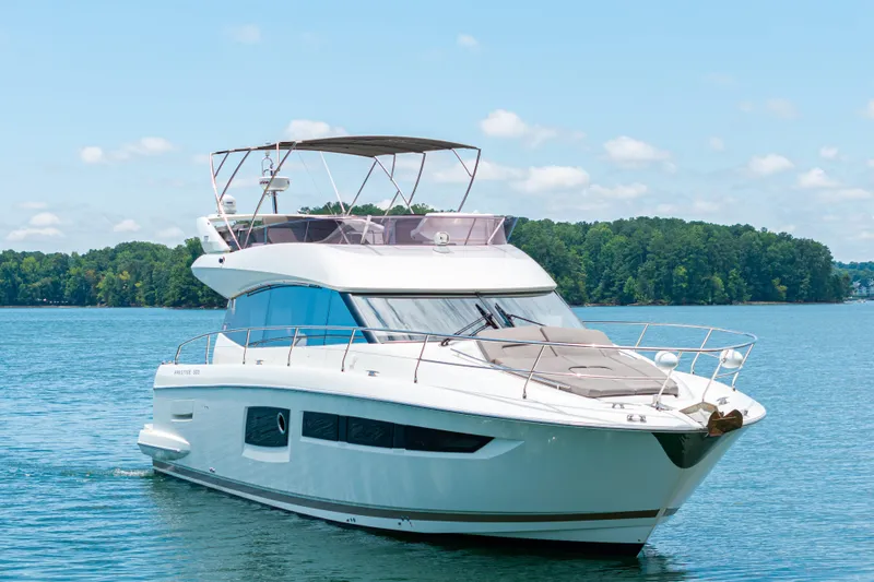  Yacht Photos Pics 2017 Prestige 500 yacht cruising on a serene lake with lush green shoreline.