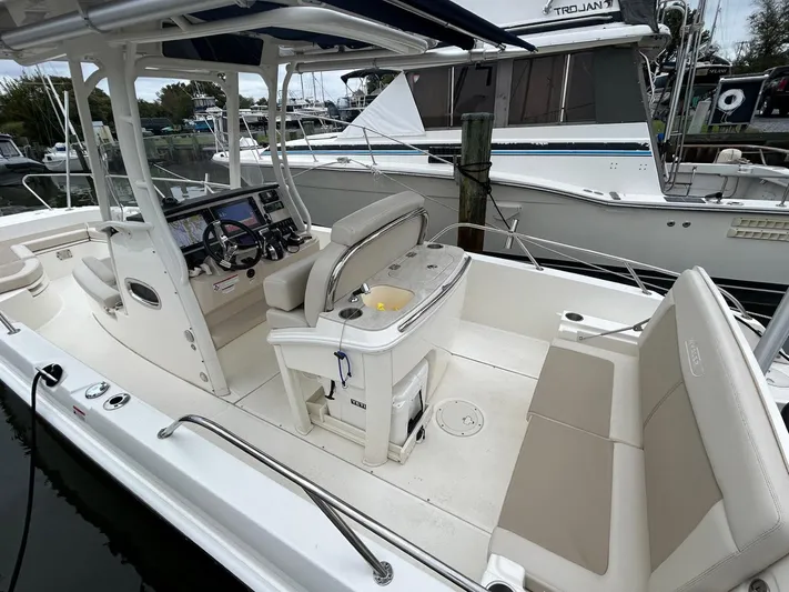  Yacht Photos Pics 2022 Boston Whaler 27 Dauntless boat interior with seating and console, docked at marina.