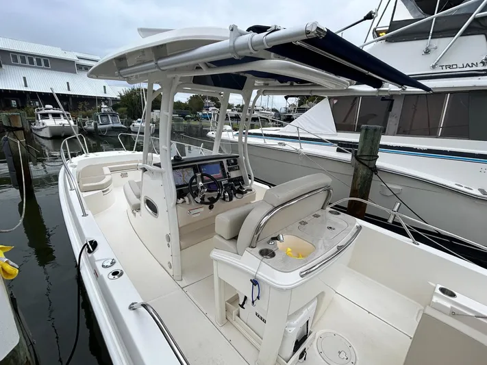  Yacht Photos Pics 2022 Boston Whaler 27 Dauntless boat docked, featuring a spacious cockpit and modern helm.