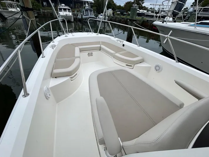  Yacht Photos Pics 2022 Boston Whaler 27 Dauntless boat interior with spacious seating in a marina setting.