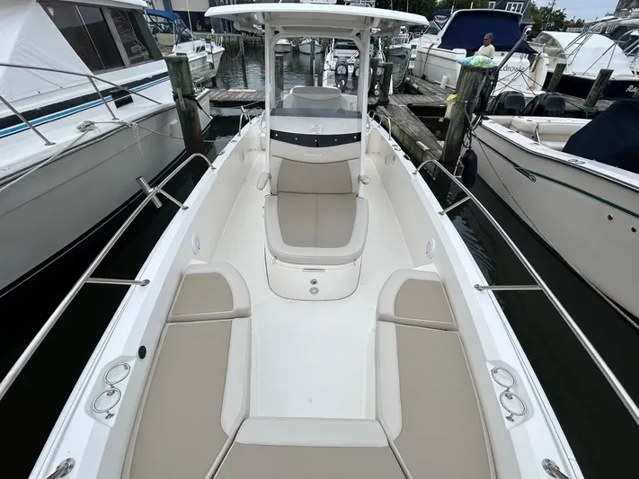  Yacht Photos Pics 2022 Boston Whaler 27 Dauntless boat docked, featuring spacious seating and sleek design.