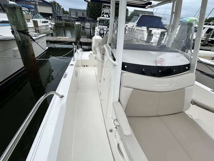  Yacht Photos Pics 2022 Boston Whaler 27 Dauntless boat docked, showcasing sleek design and spacious seating.
