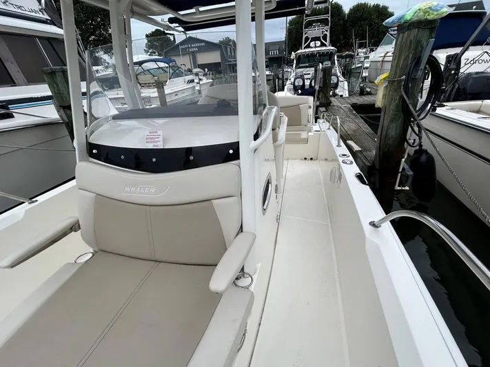  Yacht Photos Pics 2022 Boston Whaler 27 Dauntless boat docked, showcasing sleek design and spacious seating.