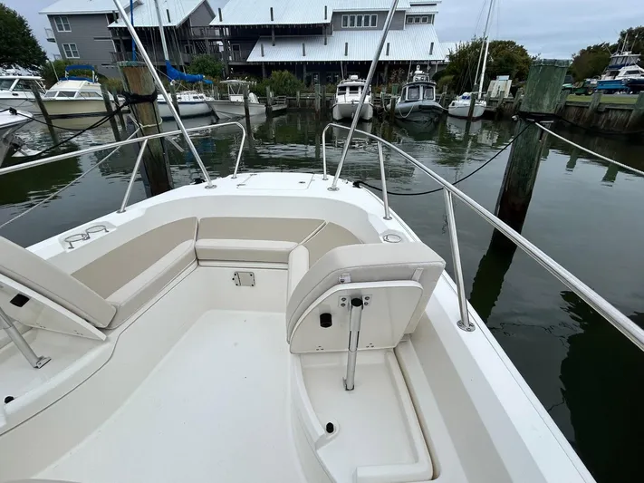  Yacht Photos Pics 2022 Boston Whaler 27 Dauntless boat docked at marina, showcasing spacious seating area.