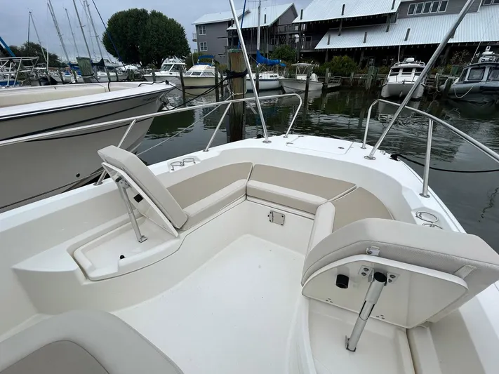  Yacht Photos Pics 2022 Boston Whaler 27 Dauntless boat with spacious seating, docked at a marina.