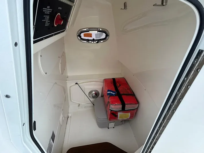  Yacht Photos Pics 2022 Boston Whaler 27 Dauntless interior storage with life jackets and control panel.