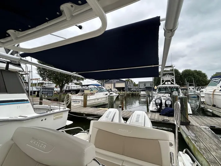  Yacht Photos Pics 2022 Boston Whaler 27 Dauntless docked at marina with canopy extended.