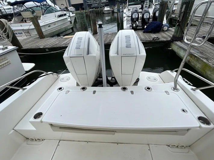  Yacht Photos Pics 2022 Boston Whaler 27 Dauntless boat with dual outboard engines at a marina.
