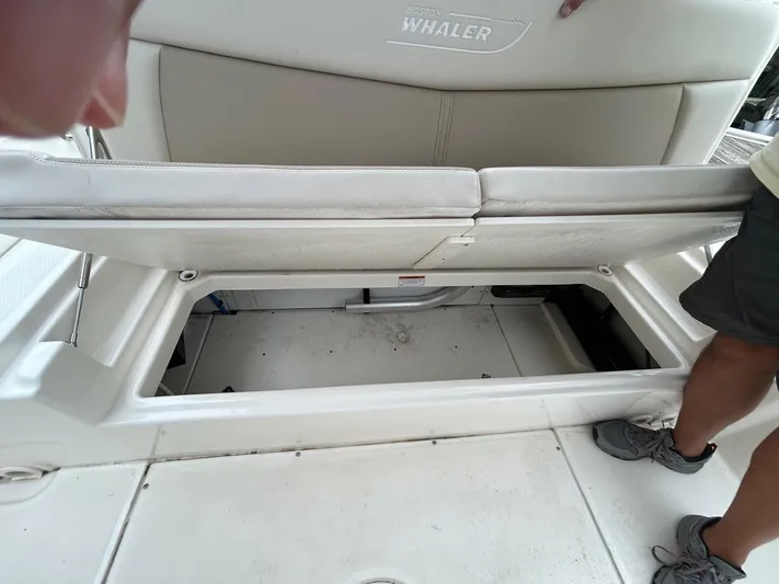  Yacht Photos Pics 2022 Boston Whaler 27 Dauntless boat storage compartment with open seat.
