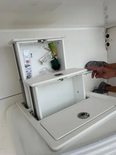  Yacht Photos Pics Storage compartment on a 2022 Boston Whaler 27 Dauntless boat, open with items inside.