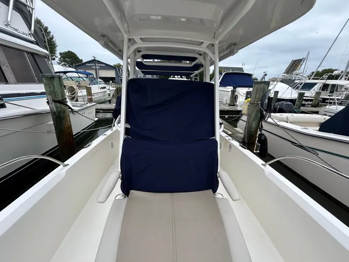  Yacht Photos Pics 2022 Boston Whaler 27 Dauntless boat interior at marina, featuring covered seating.