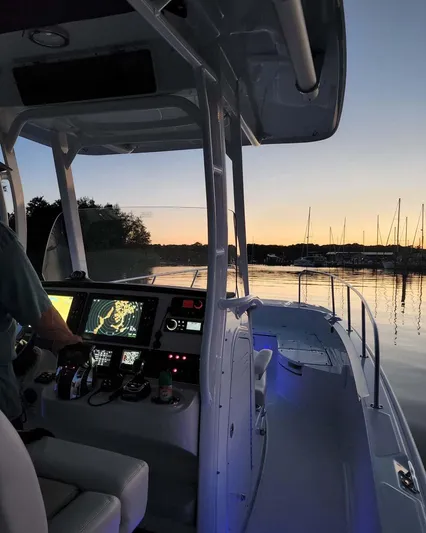  Yacht Photos Pics 2022 Boston Whaler 27 Dauntless at sunset, with illuminated dashboard and serene water view.