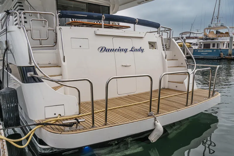 Dancing Lady Yacht Photos Pics 1999 Horizon 70 Motor Yacht docked, featuring a spacious rear deck and elegant design.