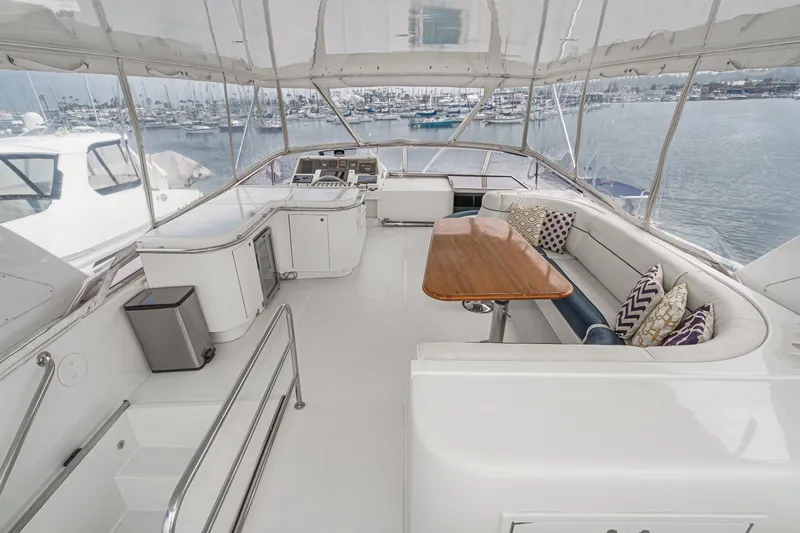 Dancing Lady Yacht Photos Pics Spacious flybridge of 1999 Horizon 70 Motor Yacht with seating and table, overlooking marina.