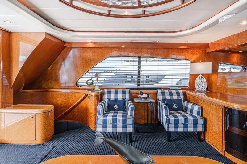 Dancing Lady Yacht Photos Pics Luxurious interior of 1999 Horizon 70 Motor Yacht with striped chairs and elegant wood finish.