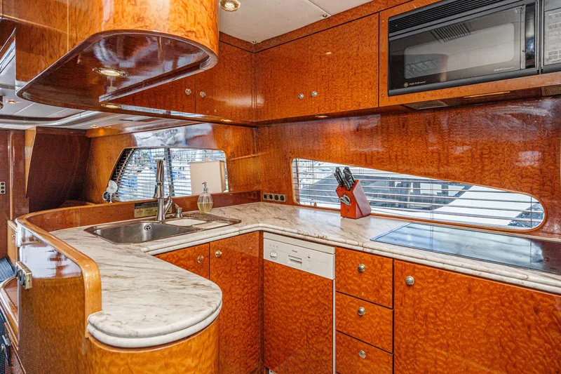 Dancing Lady Yacht Photos Pics Luxurious kitchen interior of 1999 Horizon 70 Motor Yacht with wood finish and modern appliances.