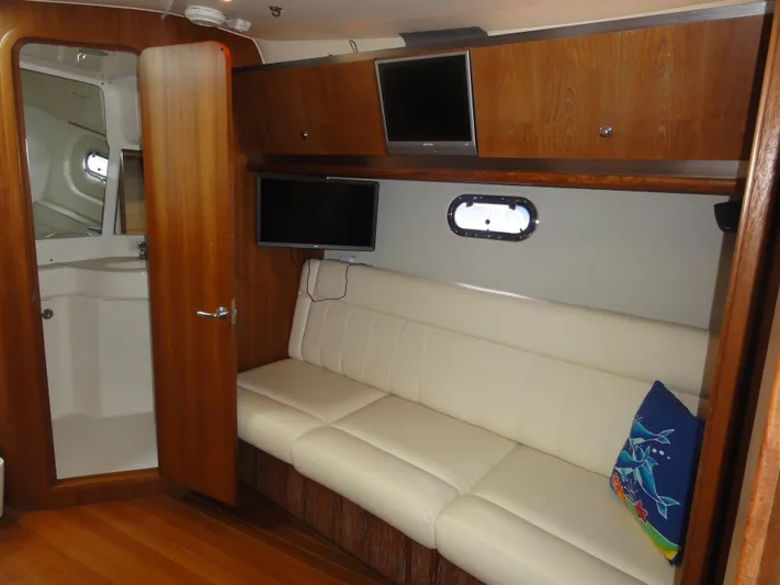  Yacht Photos Pics 2006 Tiara Yachts 3600 Sovran interior with white sofa, wooden cabinets, and small TV.