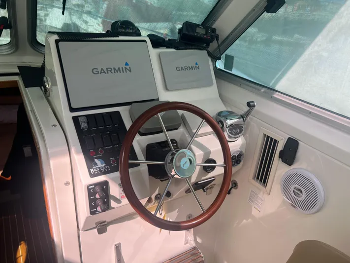 Dragonfly Yacht Photos Pics Helm of 2007 Back Cove 33 boat with Garmin navigation system and wooden steering wheel.