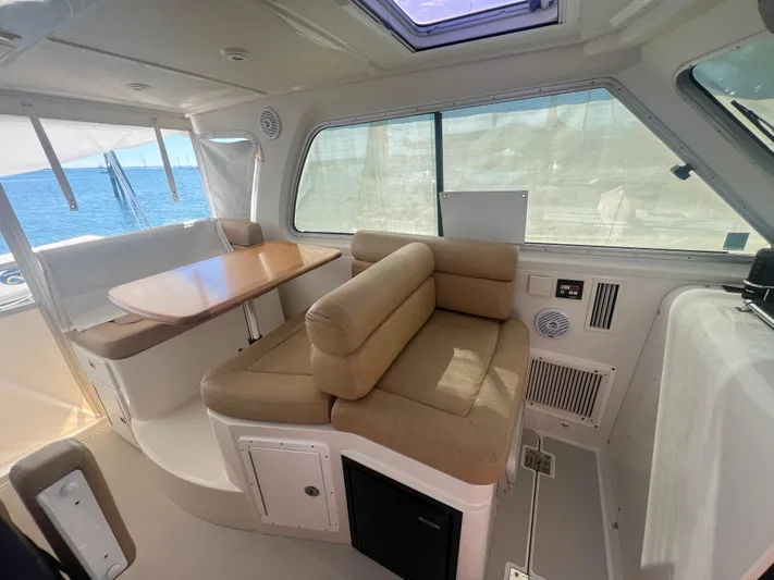Dragonfly Yacht Photos Pics Interior of a 2007 Back Cove 33 boat with beige seating and a wooden table.