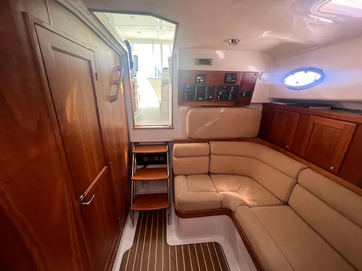 Dragonfly Yacht Photos Pics 2007 Back Cove 33 interior with wood paneling and beige seating.