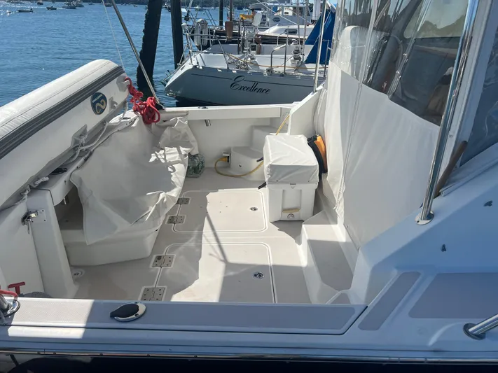 Dragonfly Yacht Photos Pics 2007 Back Cove 33 boat deck with seating and storage, docked by the water.
