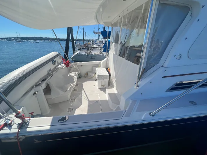 Dragonfly Yacht Photos Pics 2007 Back Cove 33 boat docked, featuring spacious deck and canopy, with scenic marina backdrop.