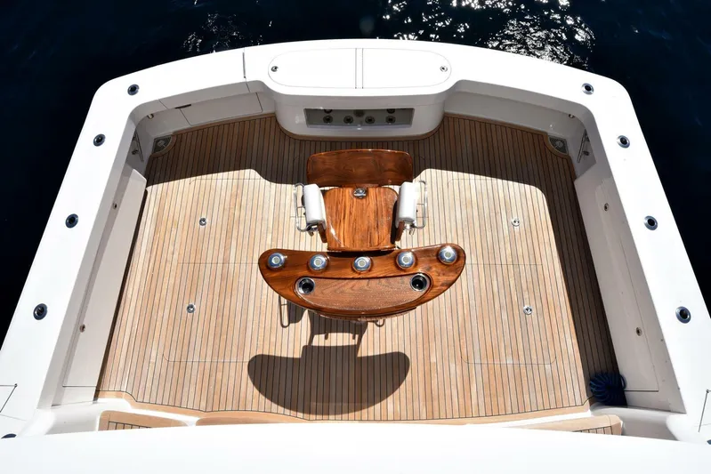 Lena Maria Yacht Photos Pics 2020 Viking 58 Convertible yacht deck with wooden chair, surrounded by sleek white railings.