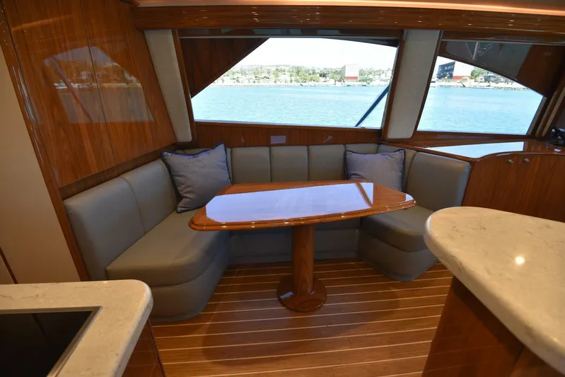 Lena Maria Yacht Photos Pics Luxurious interior of 2020 Viking 58 Convertible yacht with elegant seating and wooden table.