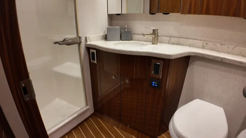 Lena Maria Yacht Photos Pics Luxurious bathroom in 2020 Viking 58 Convertible yacht with modern fixtures and wooden cabinetry.