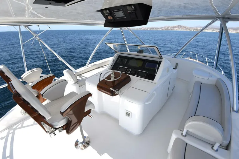 Lena Maria Yacht Photos Pics Flybridge of 2020 Viking 58 Convertible yacht with helm station and seating, overlooking ocean.