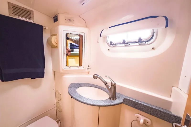 &Eacute;toile De Mer Yacht Photos Pics Compact bathroom in a 2002 Leopard 42 yacht, featuring a sink, mirror, and window.