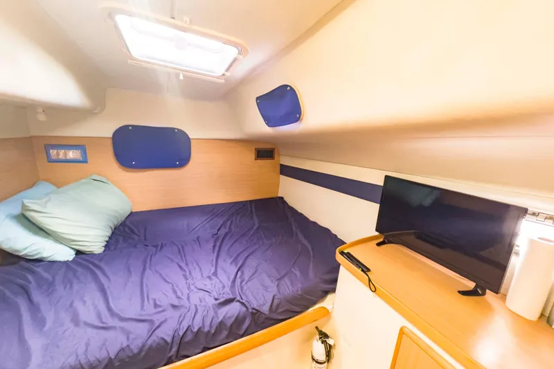 &Eacute;toile De Mer Yacht Photos Pics Cozy cabin interior of 2002 Leopard 42 yacht with bed and TV setup.