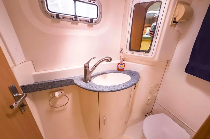 &Eacute;toile De Mer Yacht Photos Pics Compact bathroom in a 2002 Leopard 42 yacht with sink, mirror, and porthole window.
