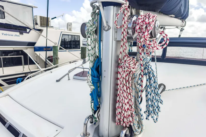 &Eacute;toile De Mer Yacht Photos Pics Sailboat deck with colorful ropes, Leopard 42 model, docked near other boats.
