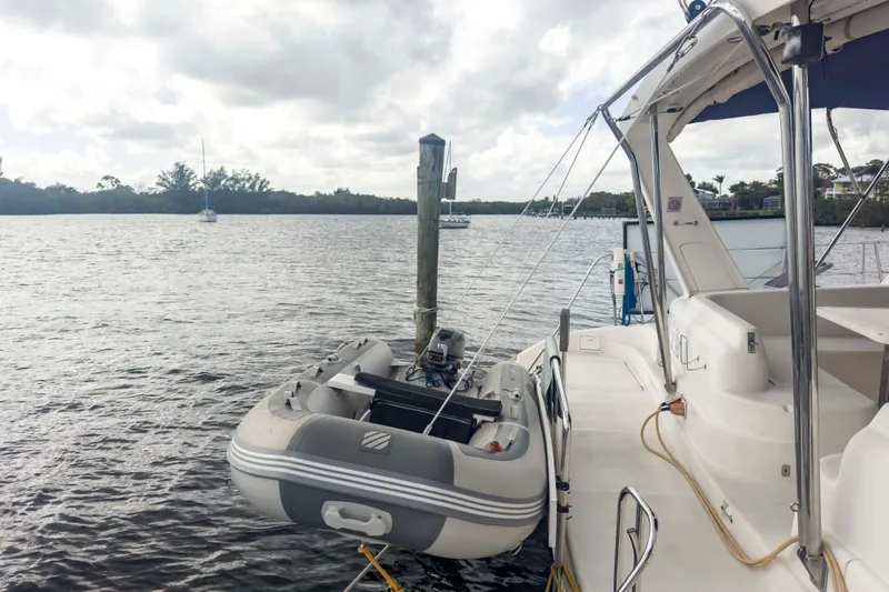 &Eacute;toile De Mer Yacht Photos Pics Leopard 42 catamaran from 2002 with dinghy, moored on a calm river.
