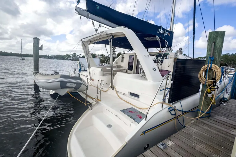 &Eacute;toile De Mer Yacht Photos Pics Leopard 42 catamaran from 2002 docked with inflatable dinghy, under cloudy sky.