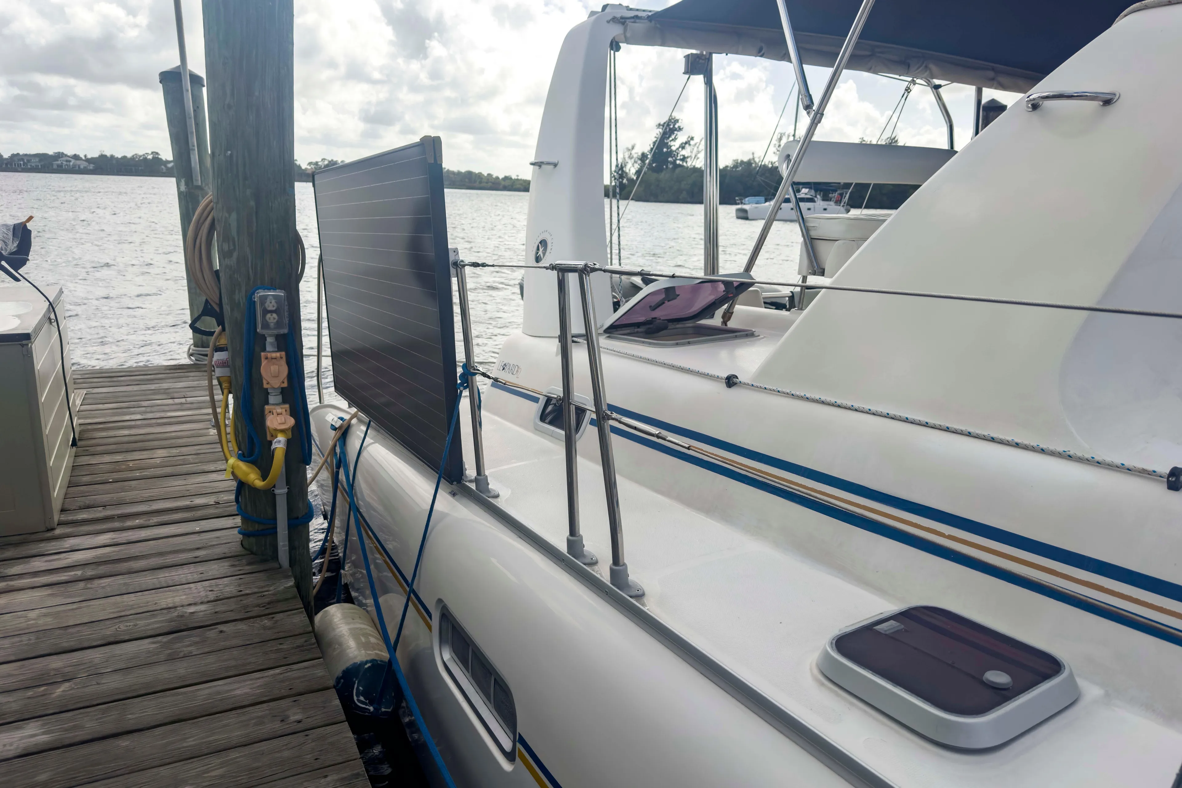 Leopard 42 catamaran docked, featuring solar panel and nautical equipment, 2002 model.