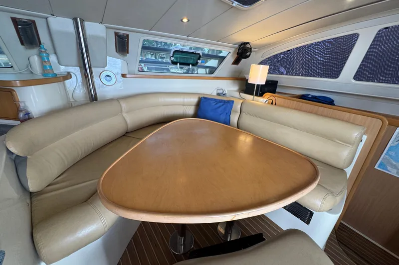 &Eacute;toile De Mer Yacht Photos Pics Luxurious interior of a 2002 Leopard 42 yacht with beige seating and wooden table.