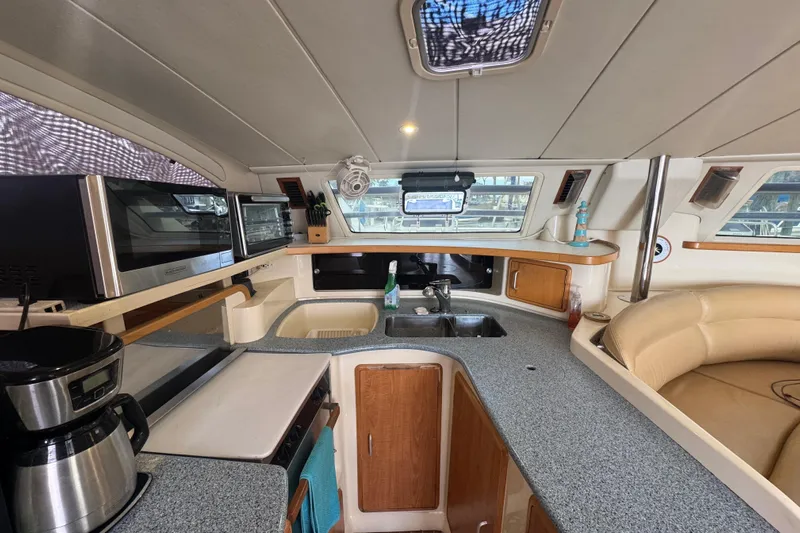 &Eacute;toile De Mer Yacht Photos Pics Interior of 2002 Leopard 42 yacht kitchen with modern appliances and seating area.