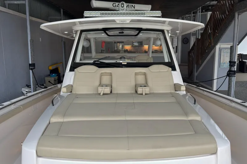  Yacht Photos Pics 2019 Pursuit S 408 Sport boat with beige seating in a covered dock.