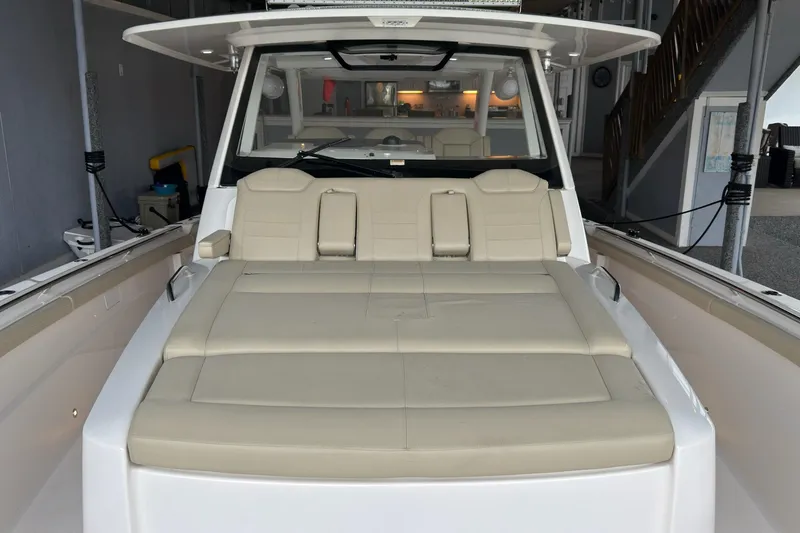  Yacht Photos Pics 2019 Pursuit S 408 Sport boat with beige seating in a marina setting.