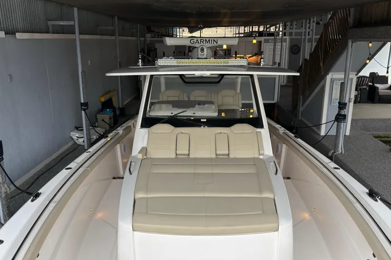  Yacht Photos Pics 2019 Pursuit S 408 Sport boat docked indoors with beige seating and Garmin equipment.