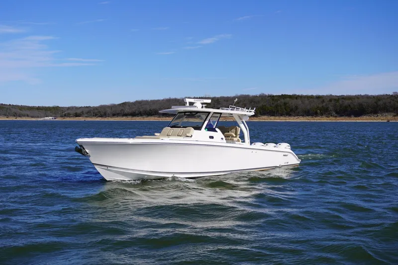  Yacht Photos Pics 2019 Pursuit S 408 Sport boat cruising on a lake under clear blue skies.