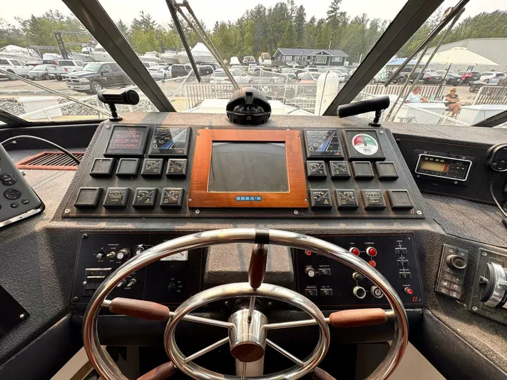  Yacht Photos Pics 1988 Bayliner 4550 Pilothouse helm with steering wheel, control panel, and navigation equipment.
